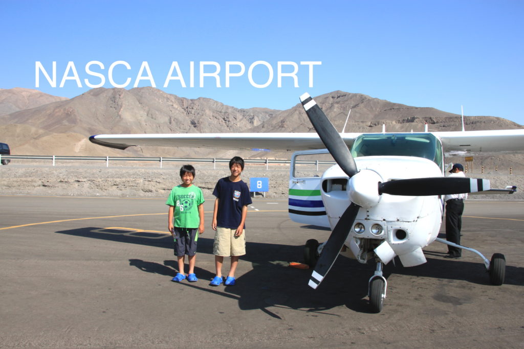 ナスカ空港の滑走路でセスナ機と一緒に子供達の記念写真