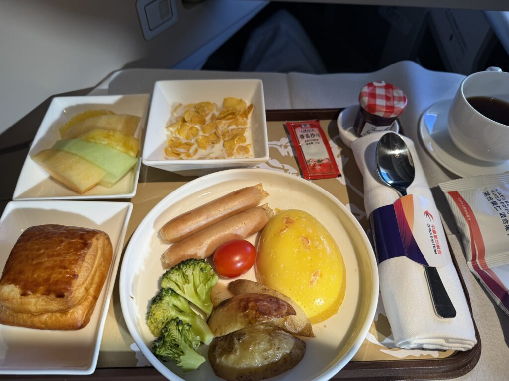 パリ到着前に出された朝食です。オムレツ、ミートパイ、コーンフレーク、フルーツ盛り合わせ
